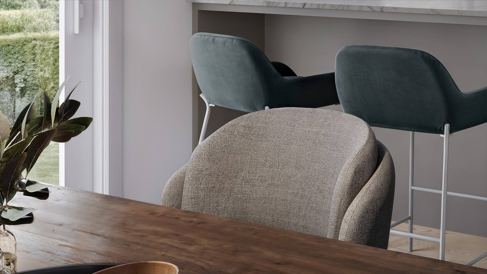 Composition intérieure 3D : fauteuil tissu texturé, tabourets velours teal et îlot cuisine en arrière-plan